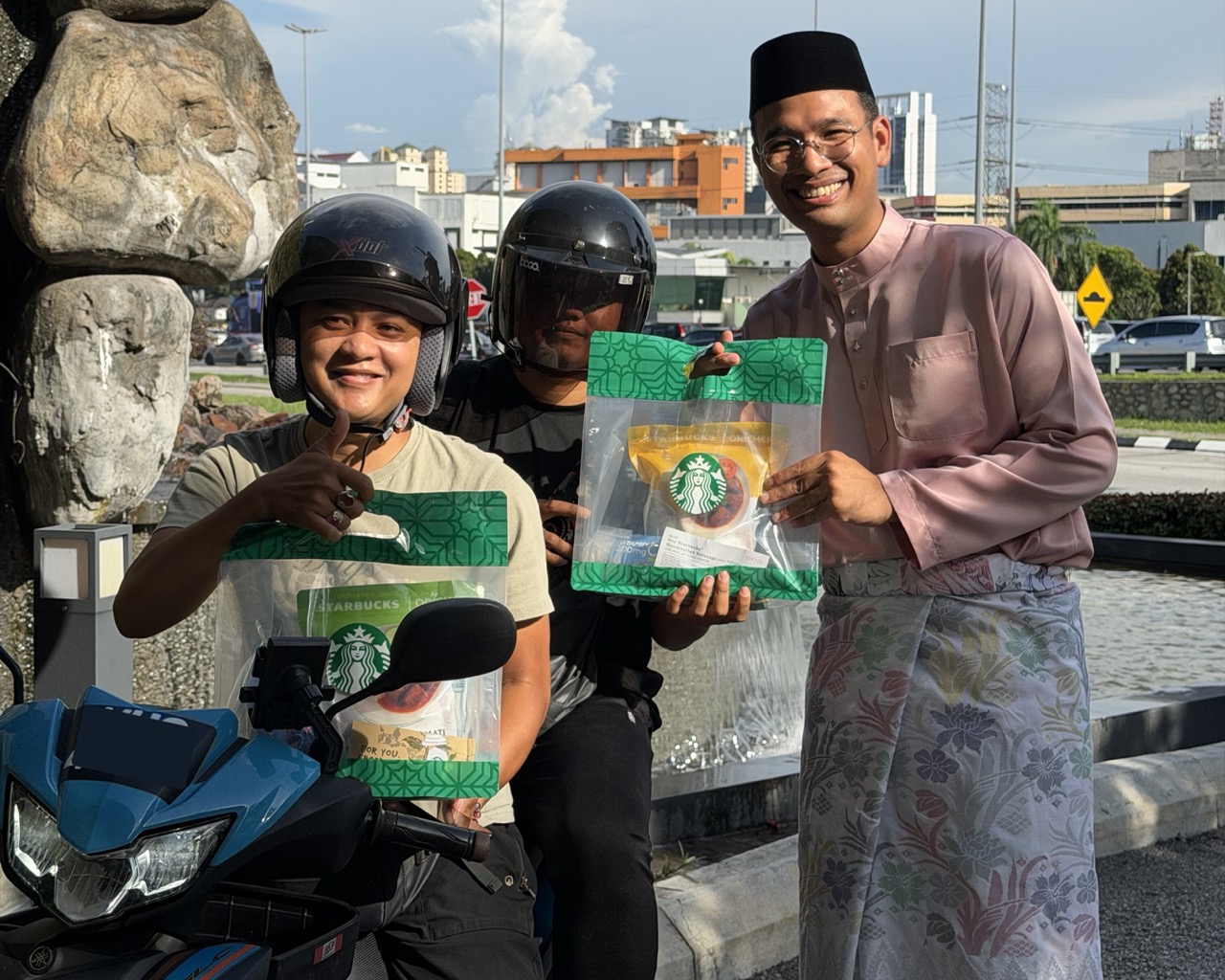 Starbucks Partner Passing Ramadan RTE Pack To Delivery Rider Large